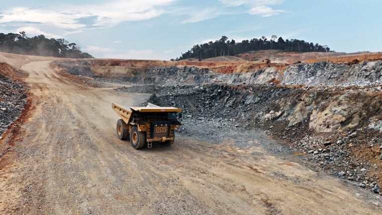 Large haul truck carrying materials along a dirt haul road inside the G Mining Ventures Tocantinzinho open-pit gold mine.