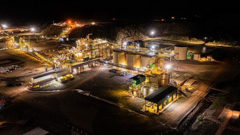 Brightly illuminated night view of an Endeavour Mining gold processing plant and CIL tanks in West Africa.