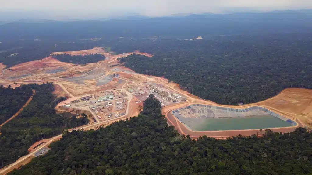 Aerial view of mining site surrounded by dense rainforest
