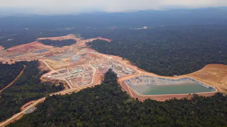 Aerial view of mining site surrounded by dense rainforest