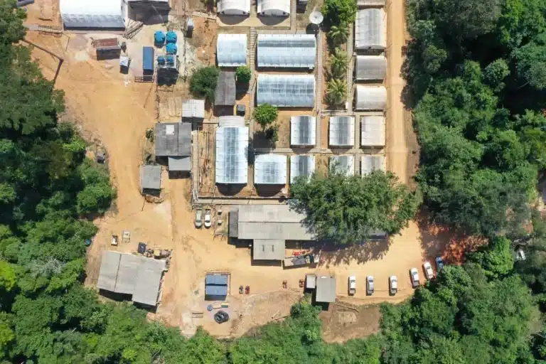 Top-down aerial view of the G Mining Ventures exploration base camp, support buildings, area bordered by forest.