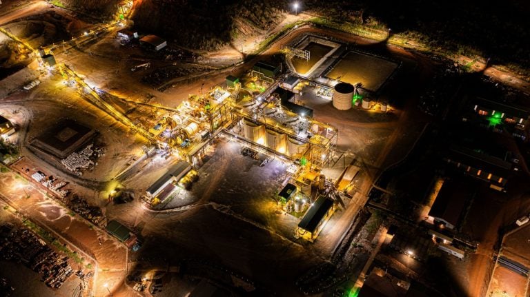 Illuminated night aerial view of an Endeavour Mining gold processing plant and facility grounds in West Africa.