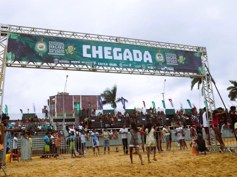 Local sports event sponsored by Belo Sun Mining with spectators gathered near a "CHEGADA" finish line banner.