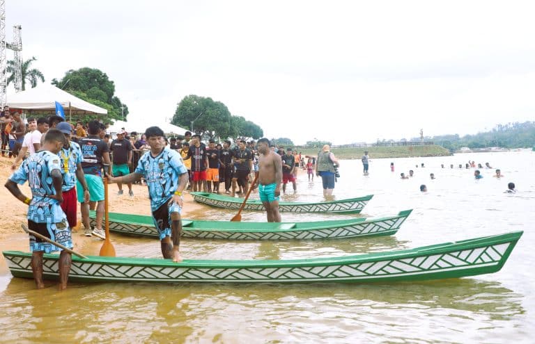 Traditional wooden canoes gathered on a riverbank during a Belo Sun Mining community activity.
