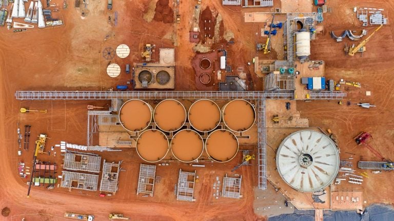 Aerial view of an Endeavour Mining gold processing facility with large storage tanks and industrial site infrastructure.