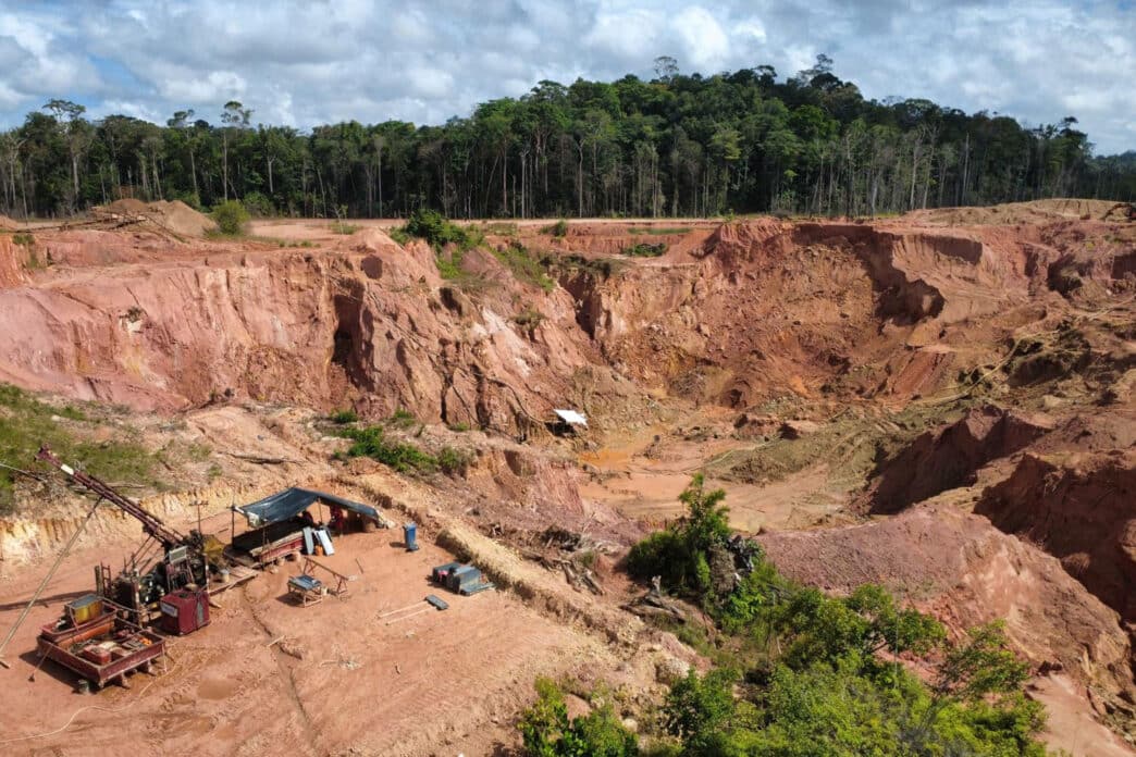 Open-pit mining site beside dense tropical forest