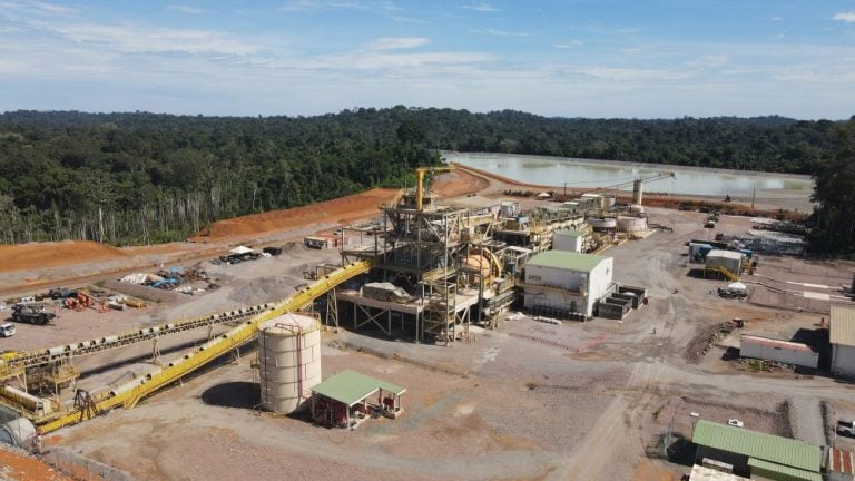Aerial view of an Endeavour Mining gold mining processing plant facility in West Africa surrounded by lush forest.
