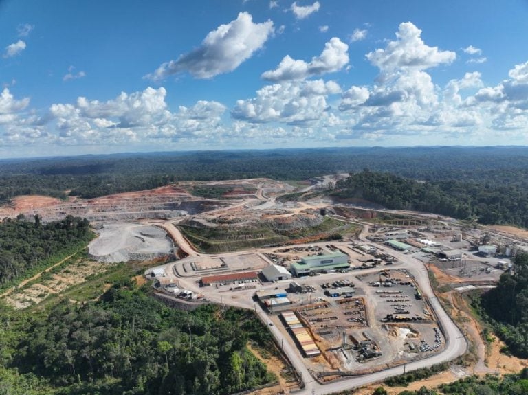 Panoramic aerial view of an Endeavour Mining gold production facility, industrial complex, and open-pit mining site surrounded by forest.
