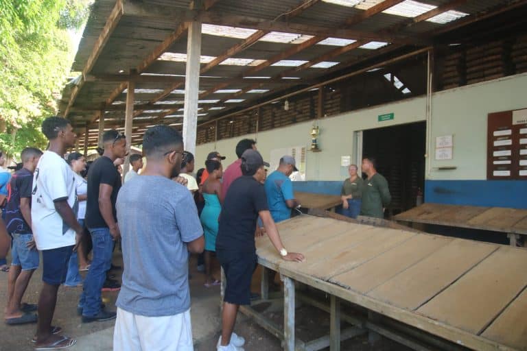 Participants attending an indoor presentation inside a Belo Sun Mining community building.